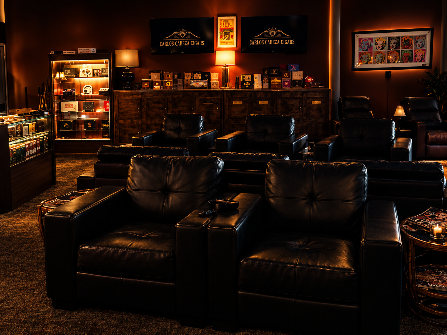 Black leather lounge seating, brass humidor cabinets and Carlos Cabeza Cigars screens inside the Galveston smoking lounge